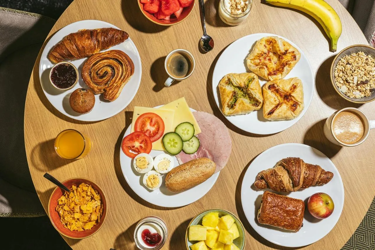 Wooden table set with breakfast dishes at Point A Hotel King's Cross